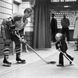 Jean Béliveau joue avec un jeune garçon.