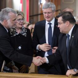 Le premier ministre du Québec Philippe Couillard serre la main de Denis Coderre, maire de Montréal, devant les yeux de Stephen Harper, premier ministre du Canada.